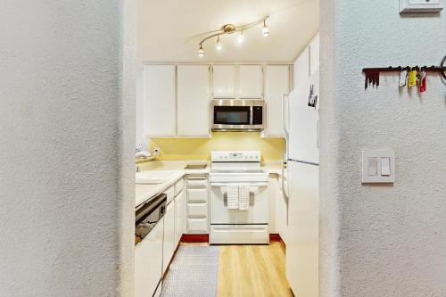 a kitchen with white cabinets and a white refrigerator at Scott Peak Views in Alpine Meadows