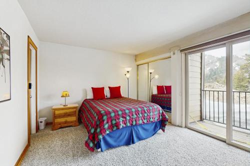 a bedroom with a bed with red pillows and a window at Scott Peak Views in Alpine Meadows