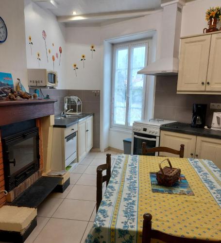 - une cuisine avec une table et une cheminée dans l'établissement Europe, à Mortagne-sur-Gironde