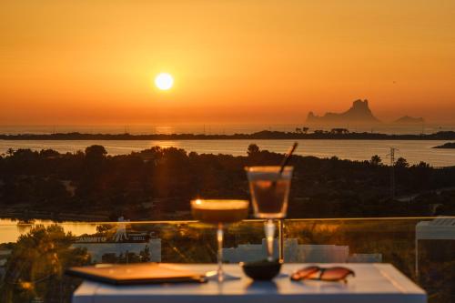 a table with a drink and a view of the sunset at Five Flowers Hotel Formentera, member of Melia Collection in Es Pujols