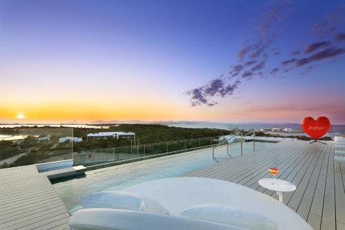 a balcony with a view of the ocean at sunset at Five Flowers Hotel Formentera, member of Melia Collection in Es Pujols