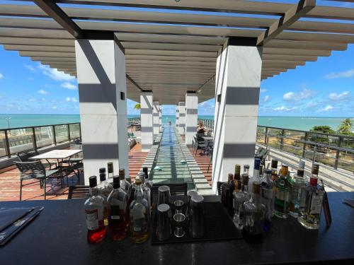 stół z butelkami alkoholu na balkonie w obiekcie Conforto ao Mar de Manaira Arpoar w mieście João Pessoa