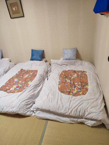 two beds sitting next to each other in a room at 北軽井沢 あさま1155 in Tsumagoi