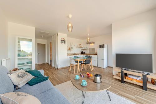 a living room with a couch and a table at Les Terrasses de la Palud in Landéda