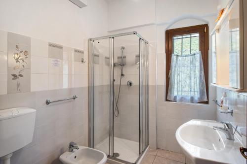 a bathroom with a shower and a toilet and a sink at Casa Rosmarino in Cisano sul Neva