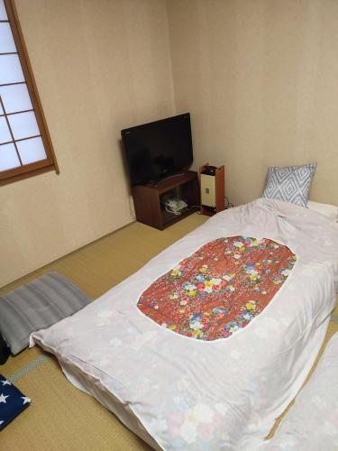 a bedroom with a large bed with a flower rug on it at 北軽井沢 あさま1155 in Tsumagoi