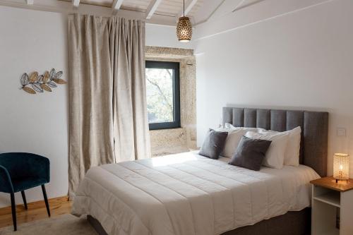 a bedroom with a large bed and a window at Quinta das Mimosas in Mondim de Basto