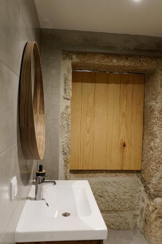 a bathroom with a sink and a wooden cabinet at Quinta das Mimosas in Mondim de Basto