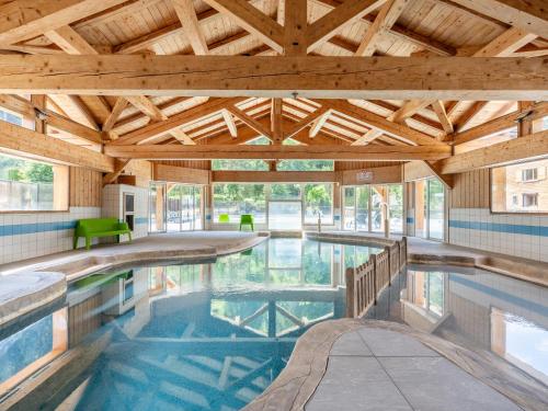 une grande piscine intérieure avec un plafond en bois dans l'établissement Appartement 10 pers avec piscine couverte près des pistes et services pratiques au Grand-Bornand - FR-1-467-105, au Grand-Bornand