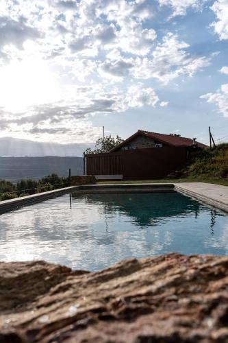 a swimming pool in front of a house at Quinta das Mimosas in Mondim de Basto