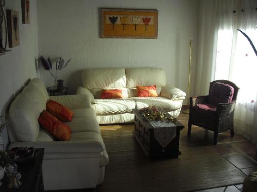 a living room with a white couch and a table at La Posada de Menchu in Sanlúcar de Barrameda