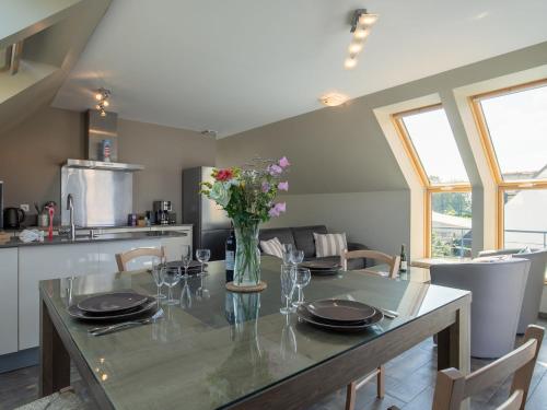 une salle à manger avec une table avec un vase de fleurs dans l'établissement Apartment Les Chardons Bleus 2 - BRP205 by Interhome, à Brignogan-Plage