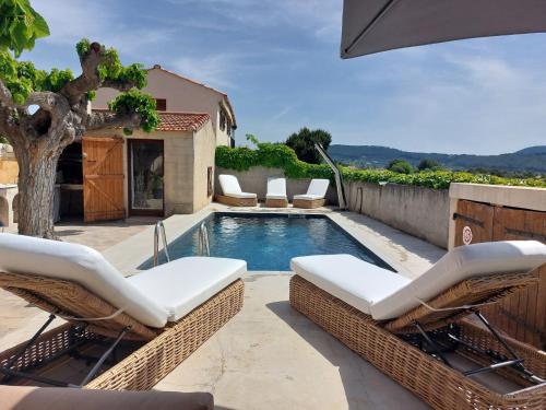 - une piscine avec des chaises en osier à côté d'une maison dans l'établissement Apartment La Bastide Neuve by Interhome, à Saint-Cyr-sur-Mer