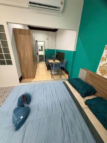 a room with a large bed and a dining room at Mamma Mia Rooms in Kata Beach