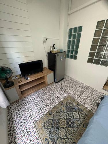 a room with a television and a tiled floor at Mamma Mia Rooms in Kata Beach