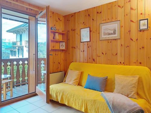 Cette chambre comprend un lit jaune et un balcon. dans l'établissement Apartment Isabella by Interhome, à Saint-Gervais-les-Bains