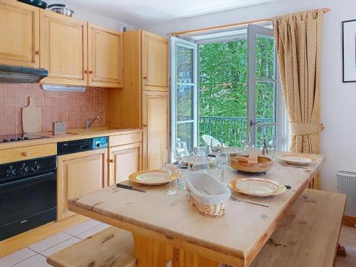 Una cocina con una mesa con platos y vasos encima. en Apartment Conseil 3 by Interhome, en Saint-Gervais-les-Bains