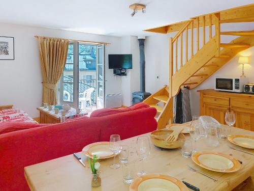 - un salon avec un canapé rouge et une table avec des verres à vin dans l'établissement Apartment Conseil 3 by Interhome, à Saint-Gervais-les-Bains