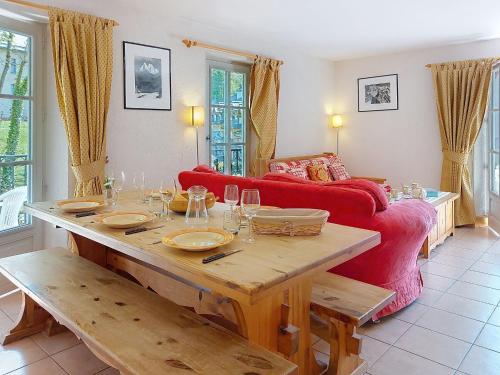Una sala de estar con una mesa y un sofá rojo. en Apartment Conseil 3 by Interhome, en Saint-Gervais-les-Bains