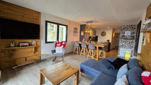 un salon avec un canapé bleu et une table dans l'établissement Le Caribou La Mongie, à Bagnères-de-Bigorre