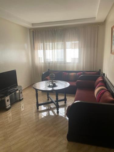 a living room with a couch and a table at Laziza in Temara