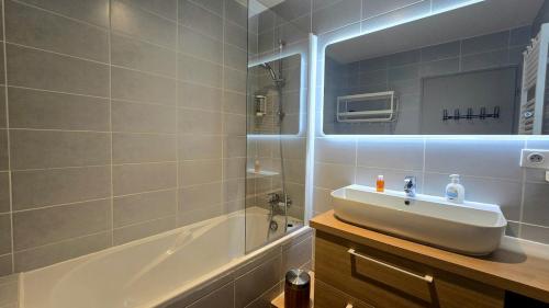 un baño con lavabo y bañera en Le Caribou La Mongie, en Bagnères-de-Bigorre
