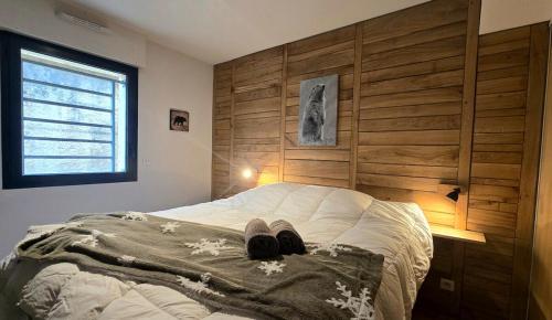 Una cama con un par de zapatos encima. en Le Caribou La Mongie, en Bagnères-de-Bigorre