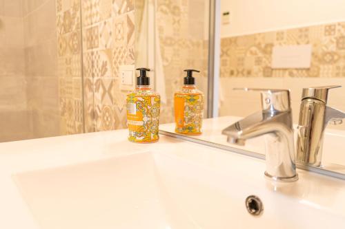 dos botellas de jabón sentadas en el lavabo del baño en Bouganville, en Posada