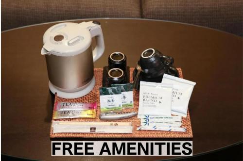 a table with a coffee mug and a sign that says free amenities at BaliAn Resort Chiba-Chuo in Chiba
