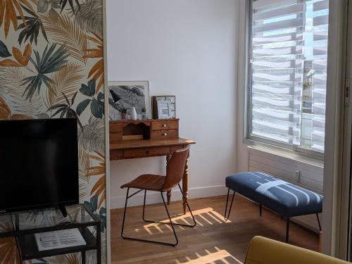 Cette chambre comprend un bureau, une chaise et une télévision. dans l'établissement CENTRE-CATHEDRALE-CORDELIERS avec garage, à Reims