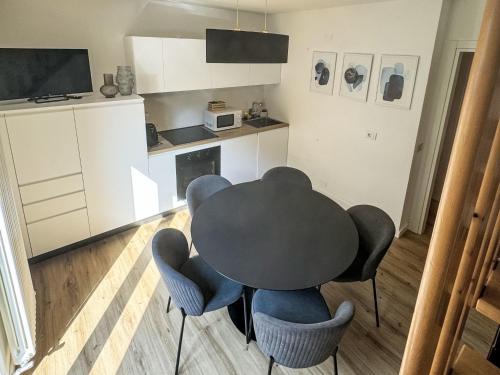 a black table and chairs in a kitchen at Apartment Dromaè-3 by Interhome in Mezzolago
