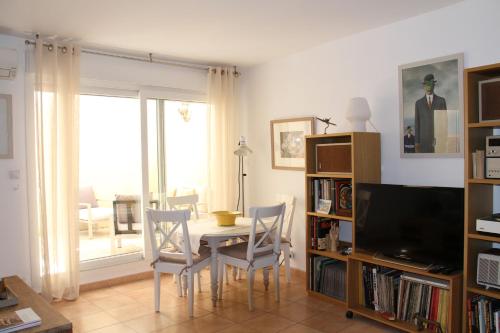a living room with a table and chairs and a television at Agréable maison de ville in Eyragues
