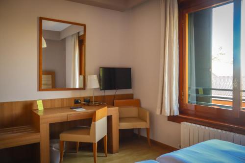 a hotel room with a desk and a mirror at Monica Hotel Fiera in Pregnana Milanese