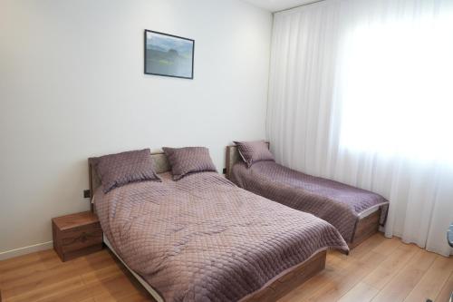 a bedroom with two beds and a window at White Harmony Houses in Şamaxı