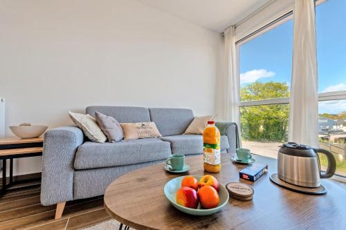 a living room with a couch and a table with fruit on it at Les Terrasses de la Palud in Landéda
