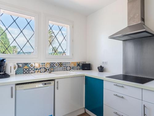 une cuisine avec des armoires blanches et une fenêtre dans l'établissement Apartment L'Aquilon by Interhome, au Pradet