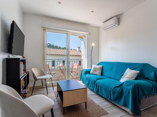 un salon avec un canapé bleu et une fenêtre dans l'établissement Apartment L'Aquilon by Interhome, au Pradet