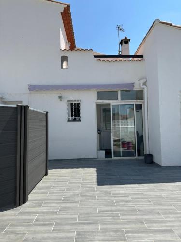 een wit huis met een poort en een oprit bij Maison 3chambres avec piscine in Istres