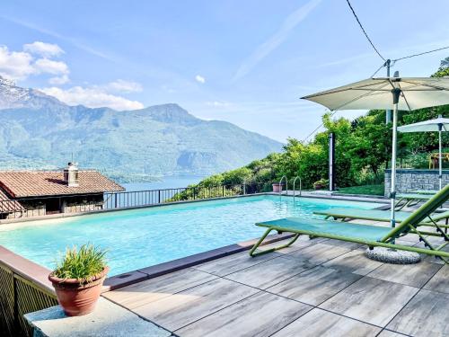a swimming pool with a bench and an umbrella at Holiday Home Tuschaus by Interhome in Domaso