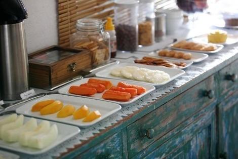 a buffet with plates of food on a table at Pousada Rosa dos Ventos in Praia do Forte