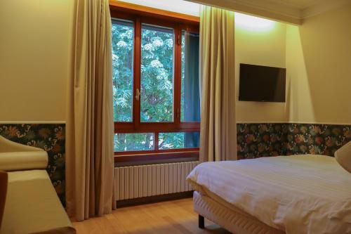 a bedroom with a bed and a window at Monica Hotel Fiera in Pregnana Milanese