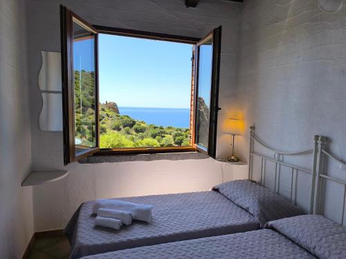 a bedroom with two beds and a large window at Villa Laura in Nebida