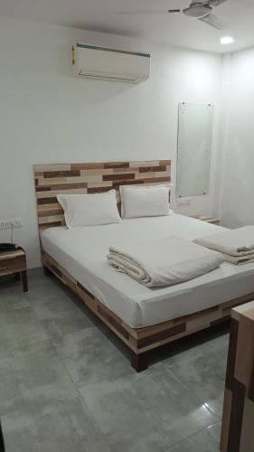 a bedroom with a large bed with white sheets at Hotel Sunshine Palace in Indore