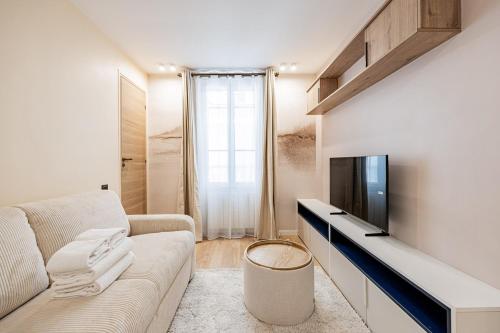 un salon avec un canapé et une télévision dans l'établissement CozyStudioParis-Montmartre-Opera, à Paris