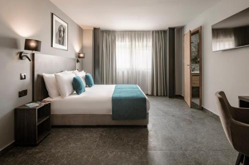 a hotel room with a bed and a desk at Spinola Hotel in St Julian's