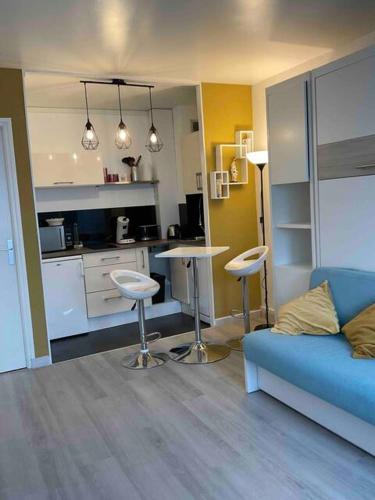 un salon avec un canapé bleu et une cuisine dans l'établissement Studio-Champagne Lanson-Proche Hôpitaux-Universités-Parc Léo Lagrange, à Reims