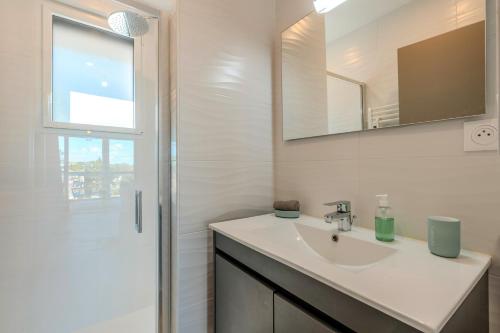 a white bathroom with a sink and a shower at Les Terrasses de la Palud in Landéda
