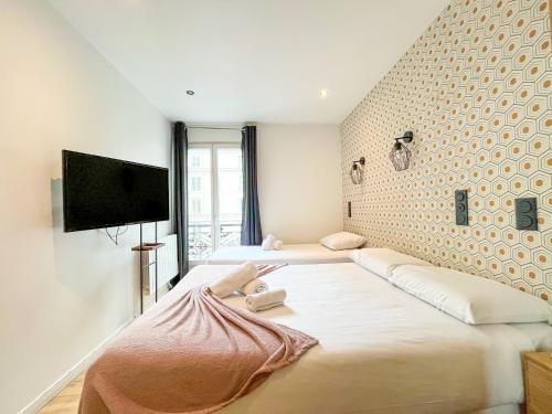 une chambre avec deux lits et une télévision à écran plat dans l'établissement Urban Flat 104 - 4 Bedroom Flat Opera, à Paris