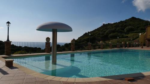 a swimming pool with a umbrella on top of it at Villa Laura in Nebida