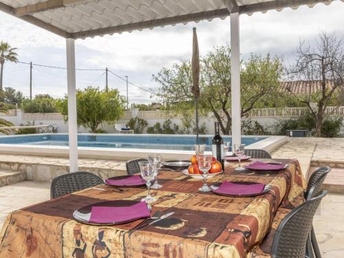 un tavolo con bicchieri da vino su un patio con piscina di Villa Junqué-Verdure by Interhome a Miami Platja